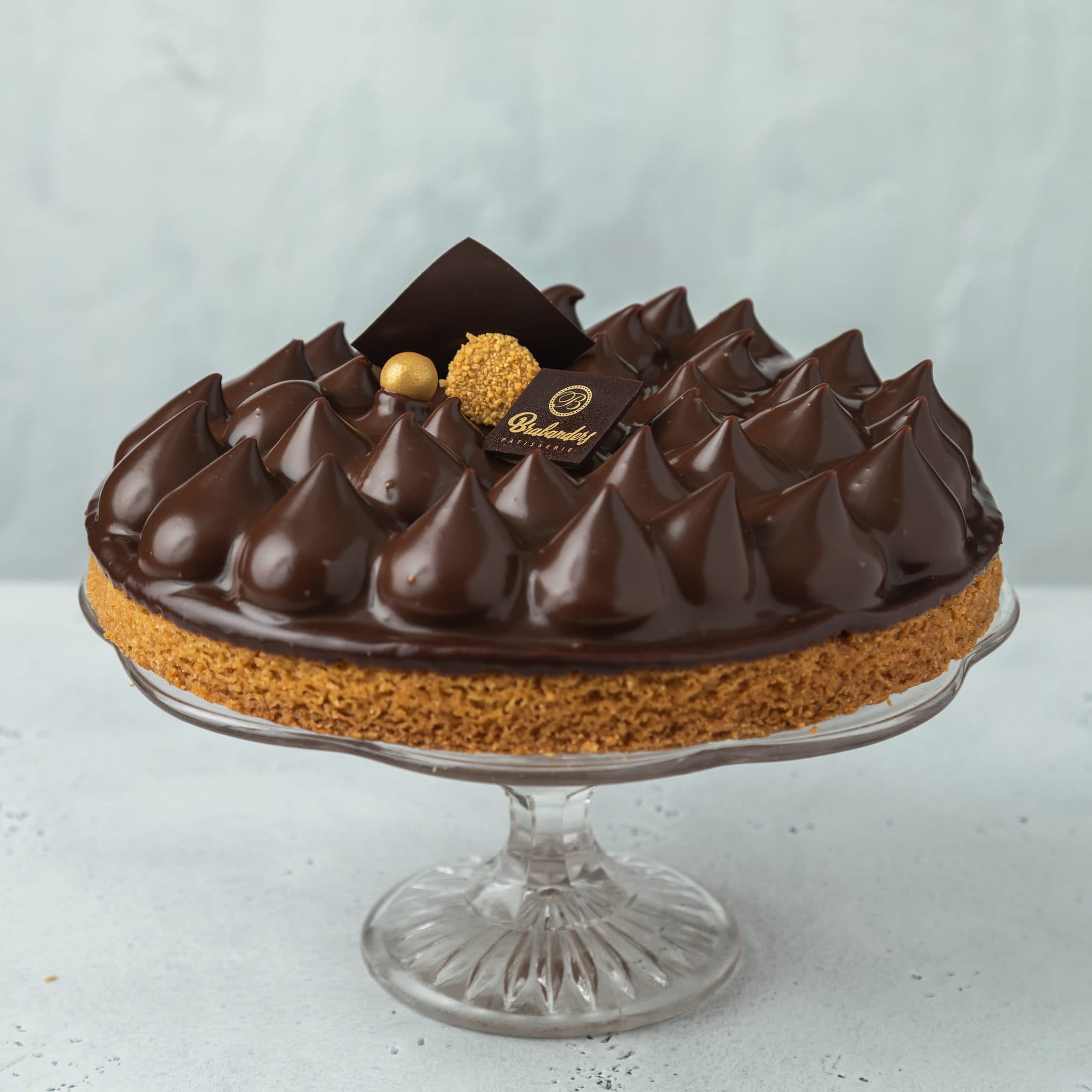 Choco-karameltaart met toefjes chocolademousse op een glazen taartplateau